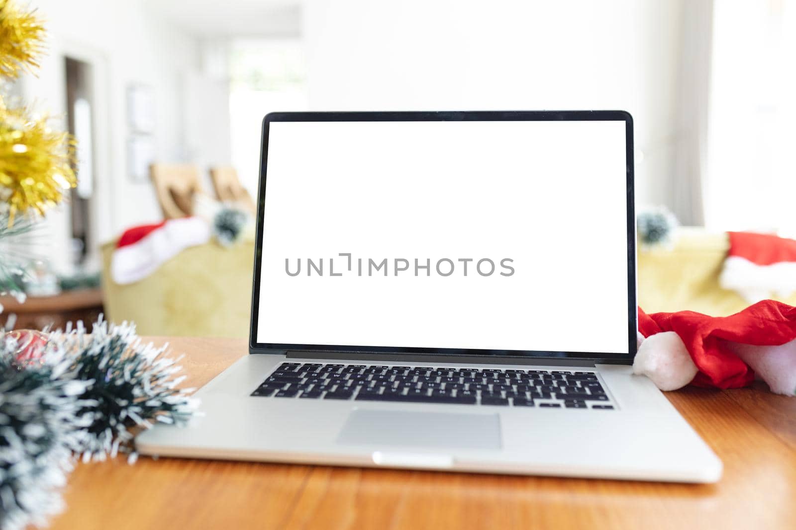 Laptop with copy space on screen lying on table with christmas decorations by Wavebreakmedia