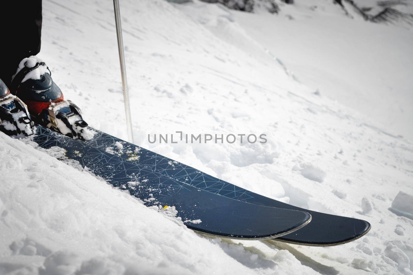 Close-up of boots and ski on a snow-covered mountain slope. Extreme sport. Winter sports concept by yanik88