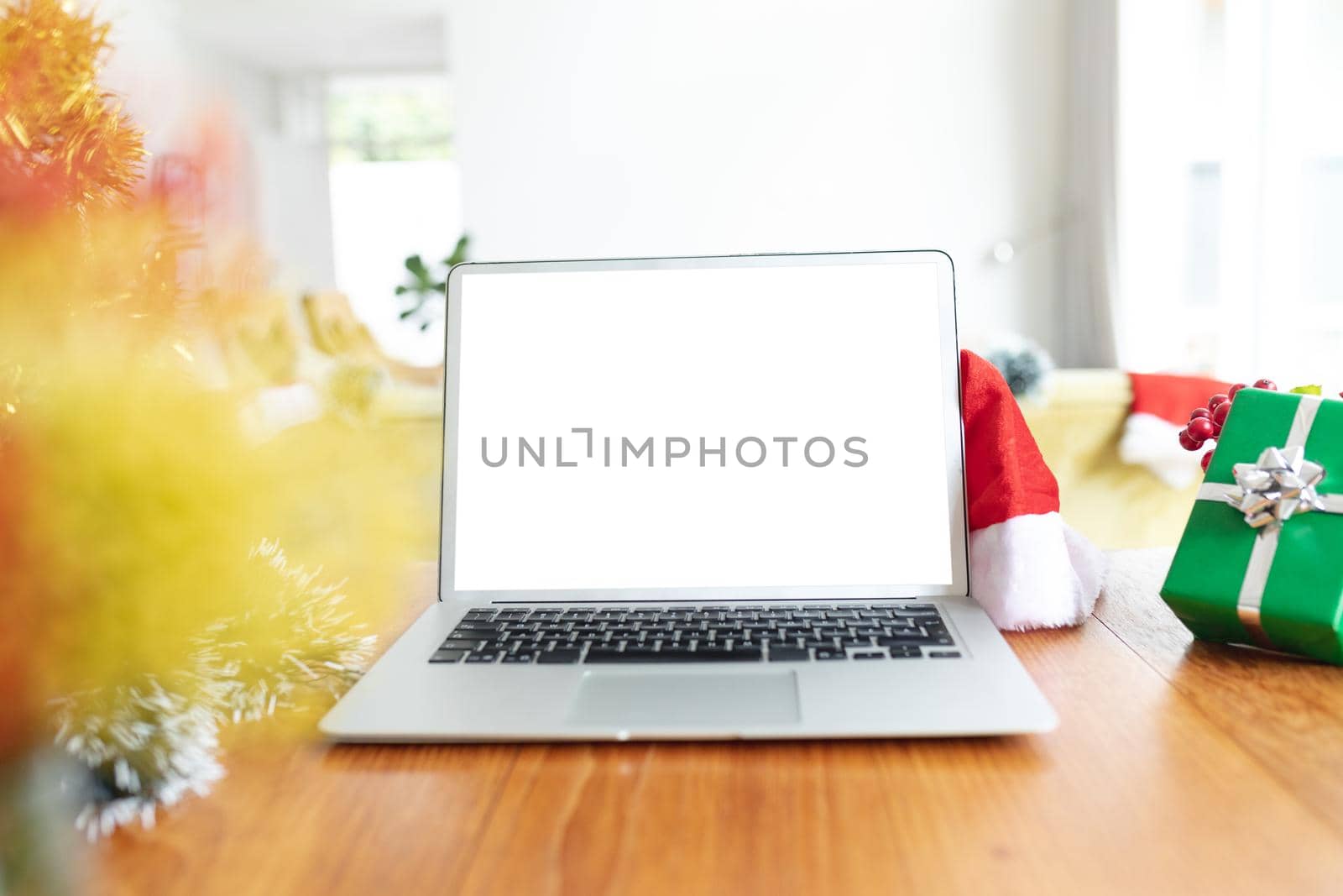 Laptop with copy space on screen lying on table with christmas decorations. christmas, festivity and communication technology.