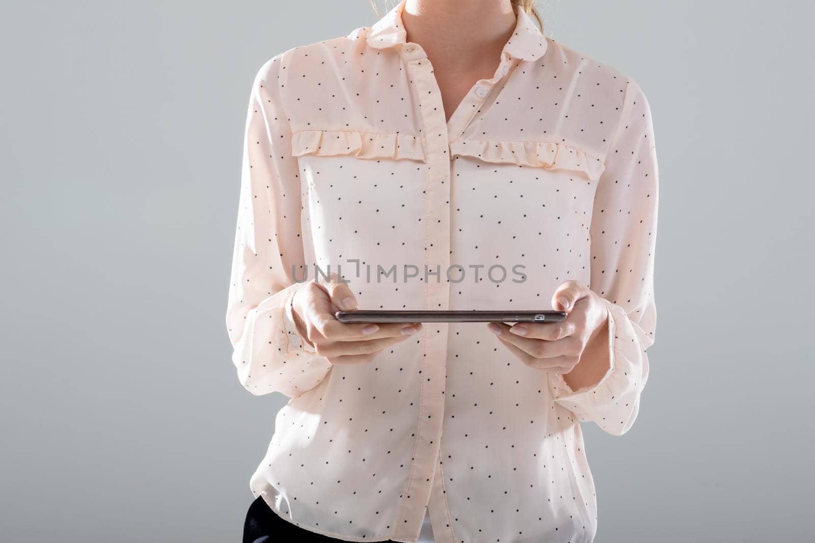 Midsection of caucasian businesswoman using tablet, isolated on grey background. business, technology, communication and growth concept.