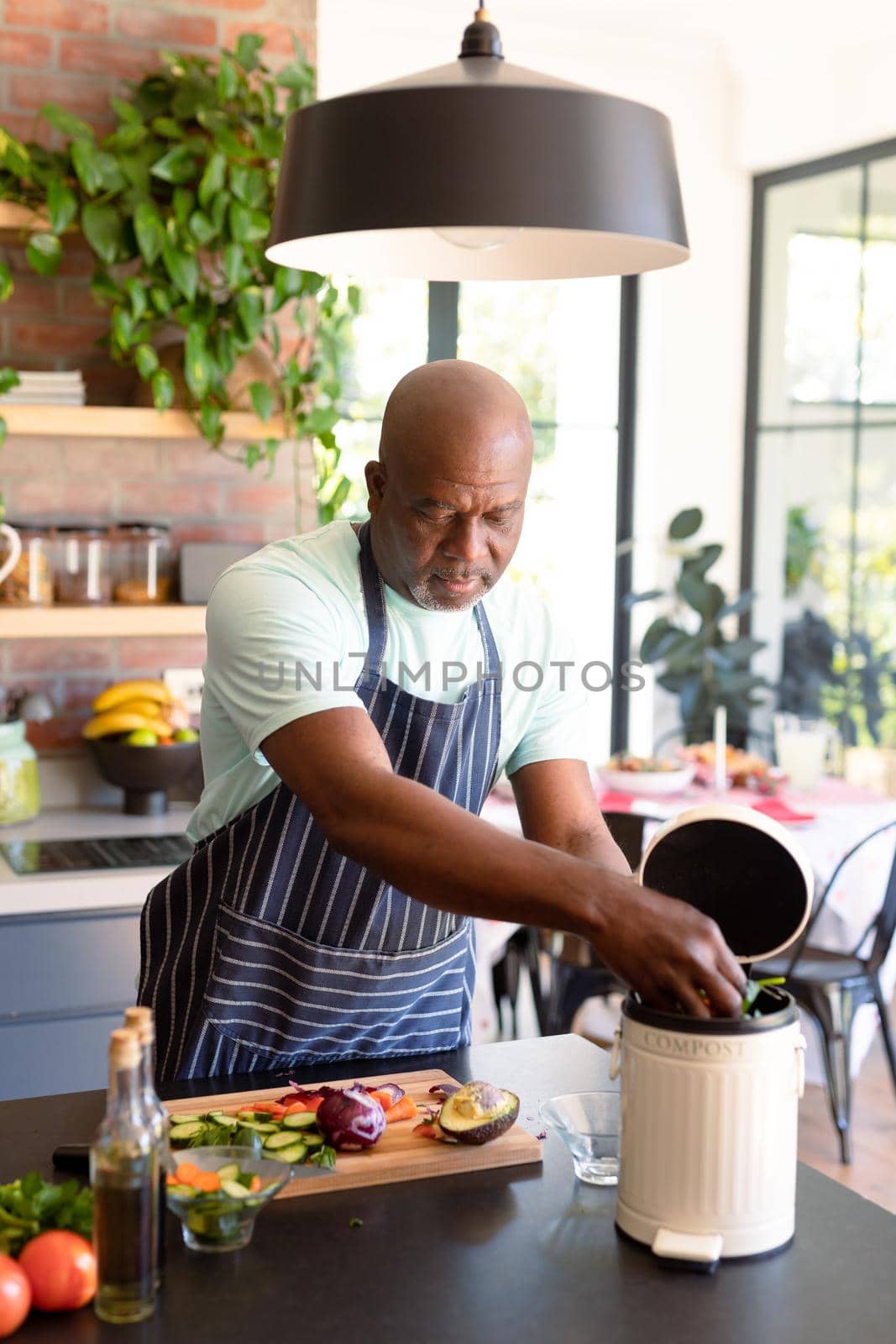 Serious african american senior man cooking in kitchen by Wavebreakmedia