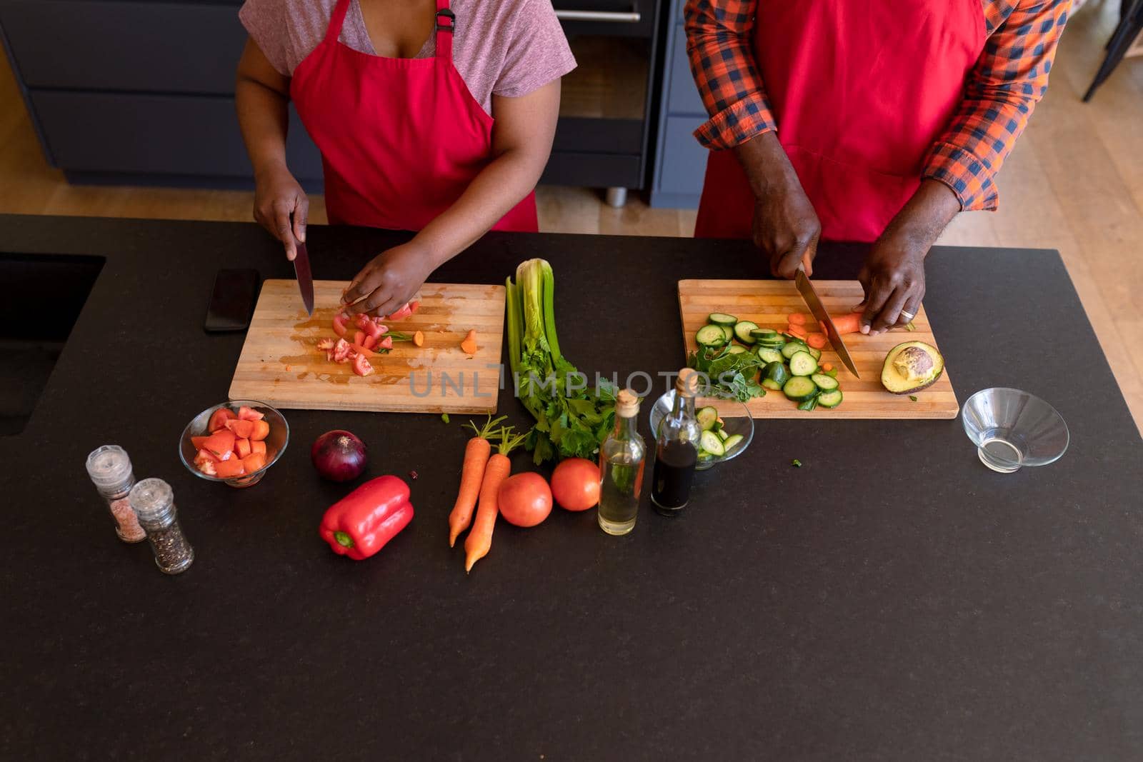 Midsection of african american senior couple cooking together in kitchen by Wavebreakmedia