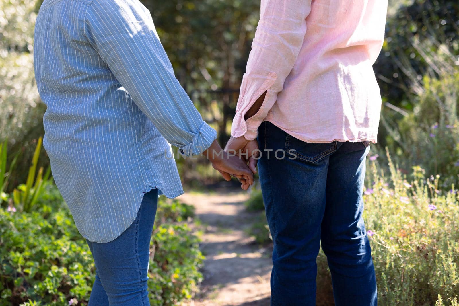 Midsectin of happy african american senior couple holding hands outdoors by Wavebreakmedia