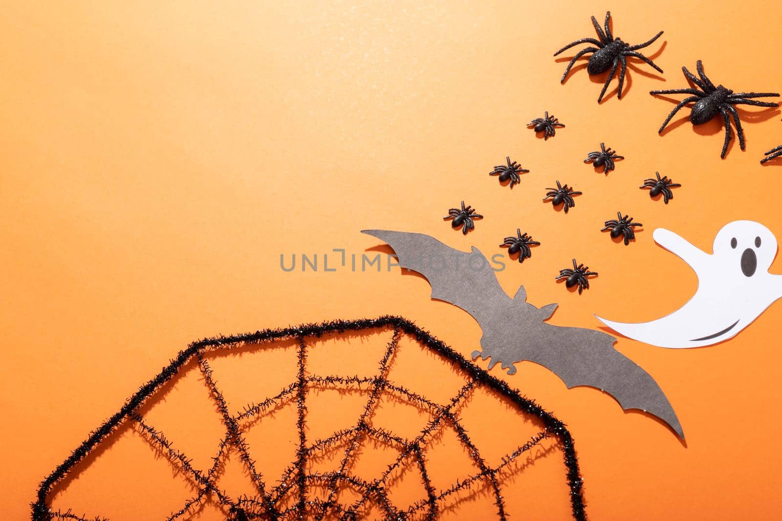 Composition of halloween decorations with rows of black spiders, spider web and ghost on orange by Wavebreakmedia