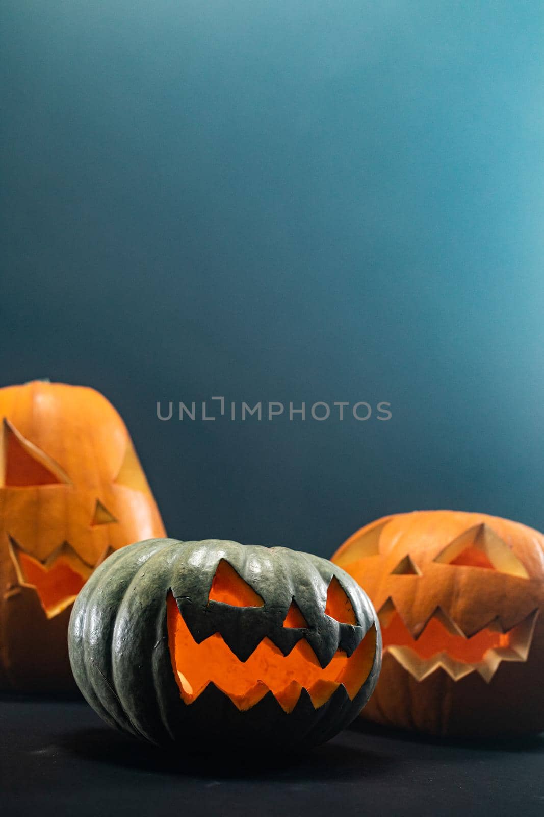 Composition of halloween carved pumpkins with copy space on blue background. halloween tradition and celebration concept.