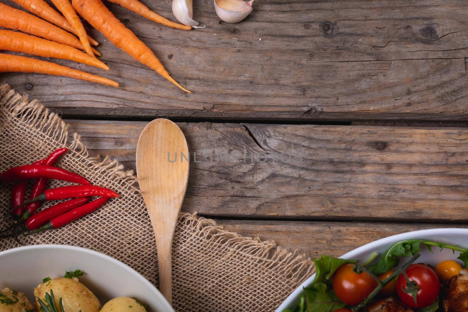 Composition of autumn halloween food chilli peppers, carrots with copy space on wooden background. autumn, halloween tradition, food, cooking and celebration concept.