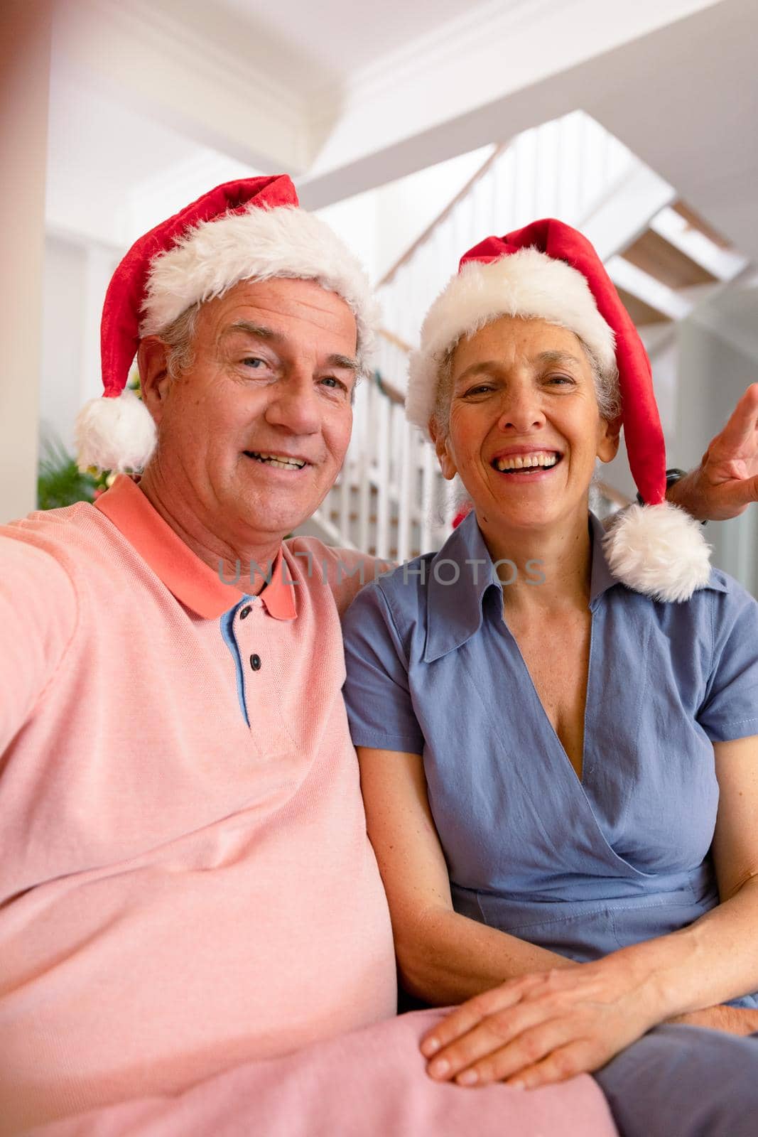 Happy caucasian senior couple wearing santa hat, having video call at christmas time by Wavebreakmedia