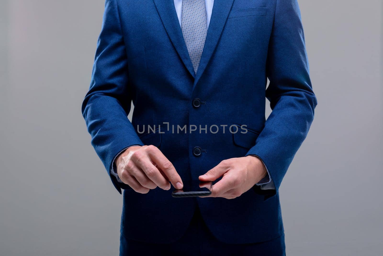 Midsection of caucasian businessman using smartphone, isolated on grey background. business technology, communication and growth concept.