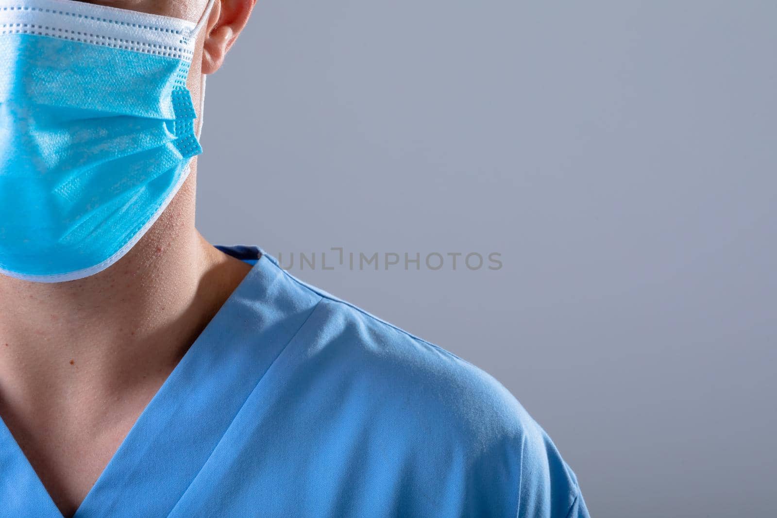Caucasian male doctor wearing face mask, isolated on grey background by Wavebreakmedia