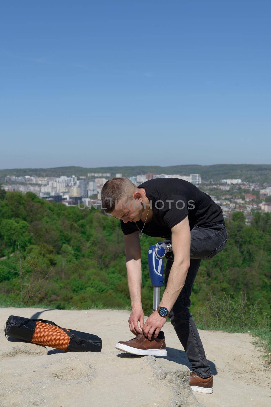 a man on a prosthetic leg travels the mountains. Dressed in black jeans and a T-shirt