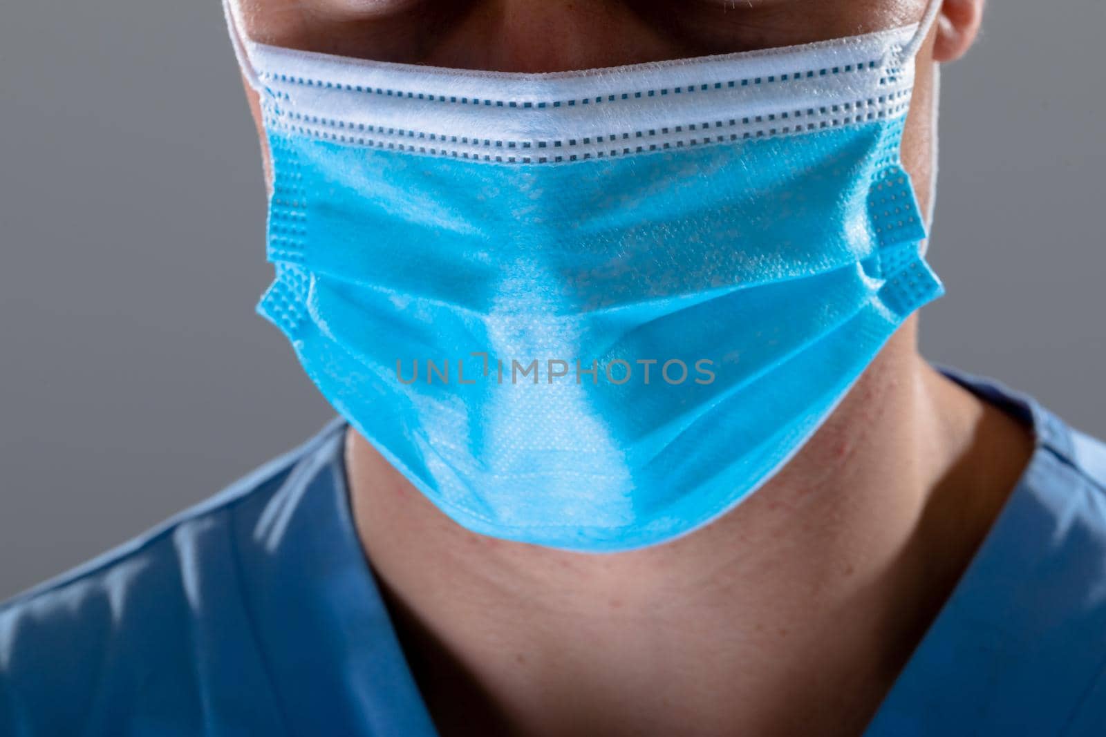 Caucasian male doctor wearing face mask, isolated on grey background. medical and healthcare technology concept during covid 19 coronavirus pandemic concept digitally generated composite image.