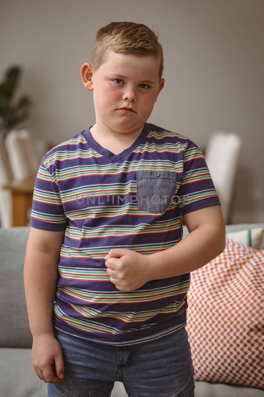 Portrait of caucasian boy making hand gestures sitting on the couch at home by Wavebreakmedia