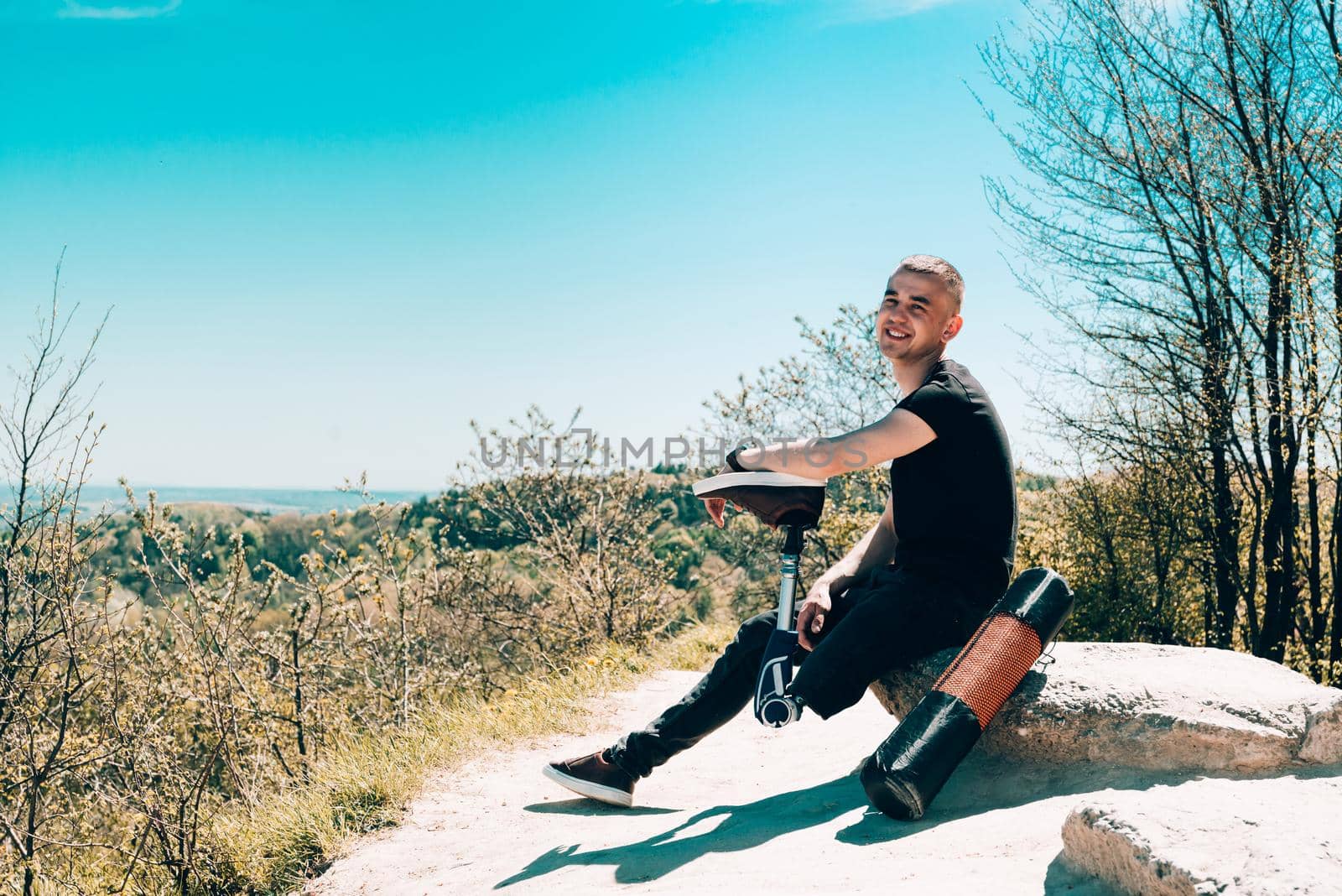 a man on a prosthetic leg travels the mountains. Dressed in black jeans and a T-shirt by Ashtray25