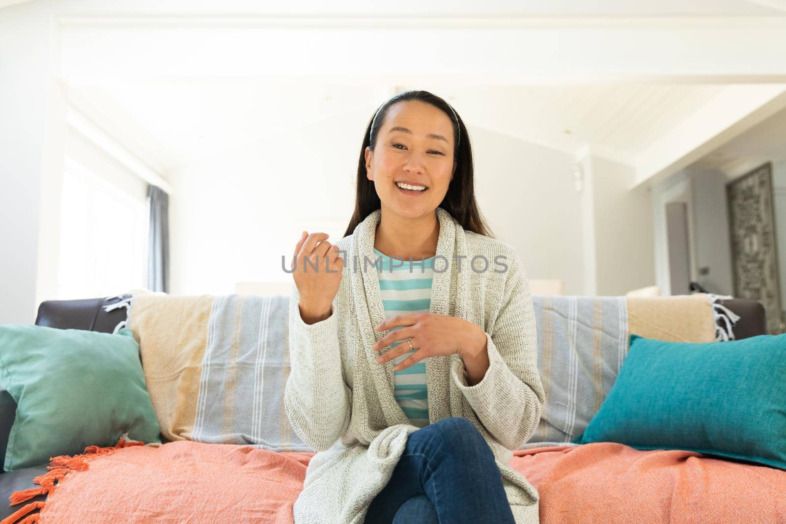 Asian woman smiling during video call at home. domestic lifestyle and working online during covid 19 pandemic concept.