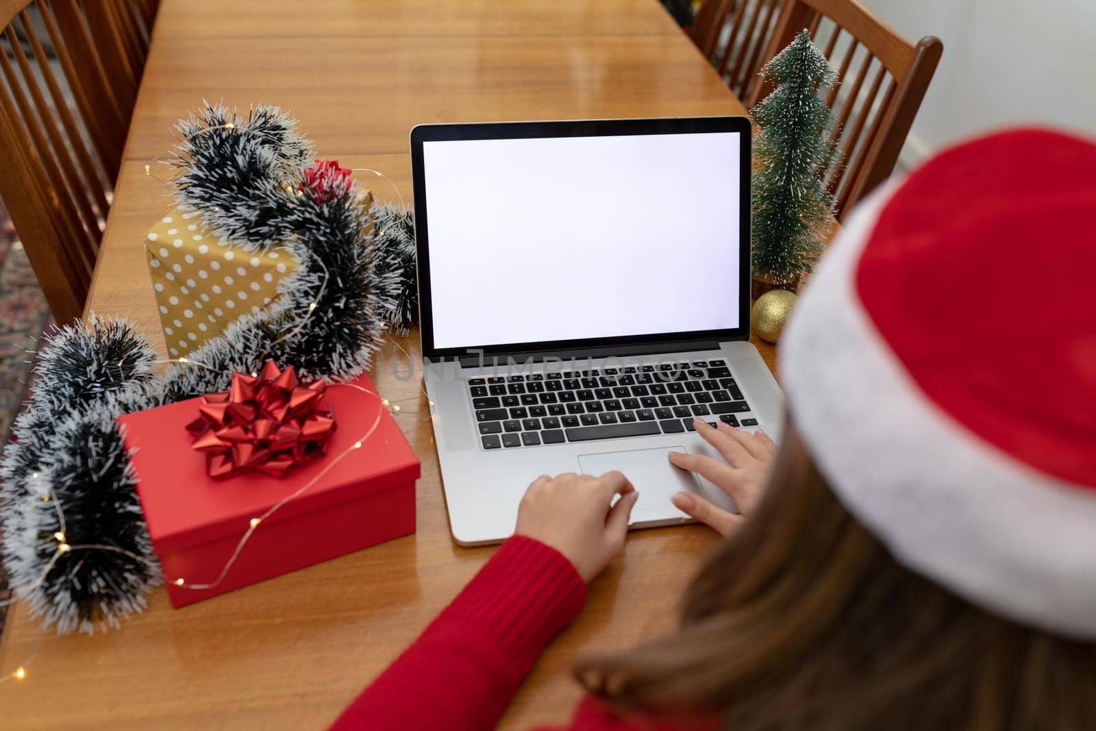 Caucasian woman wearing santa hat having video call on laptop with copy space at christmas time by Wavebreakmedia