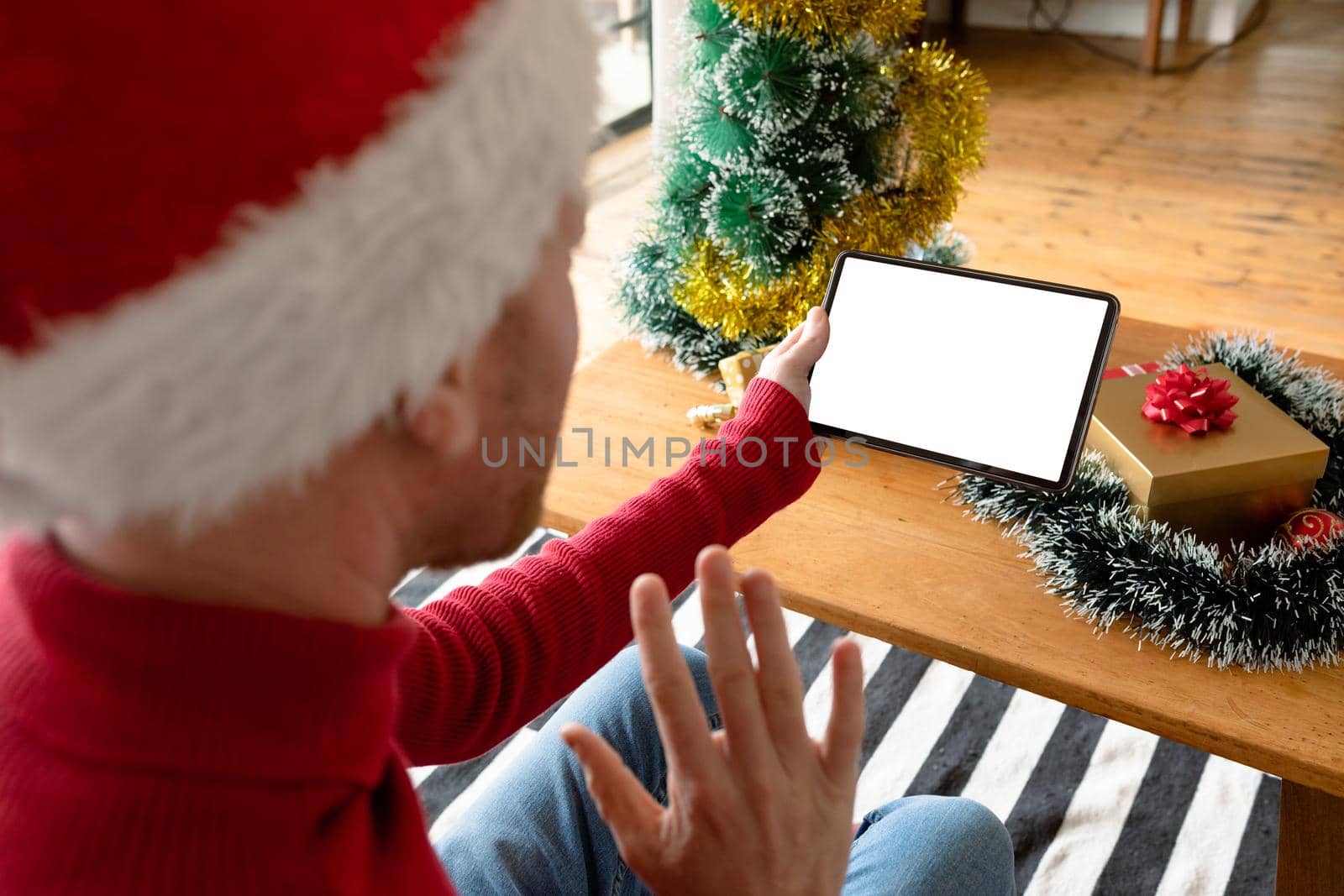 Albino african american man wearing santa hat making video call on tablet with copy space. christmas, festivity and communication technology festivity and communication technology.