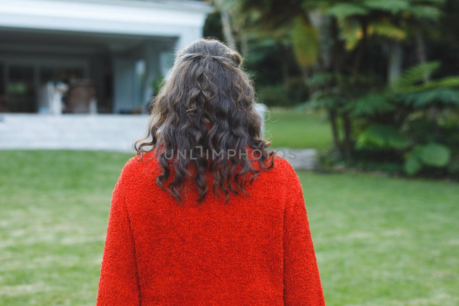 Rear view of senior caucasian woman walking in her garden by Wavebreakmedia