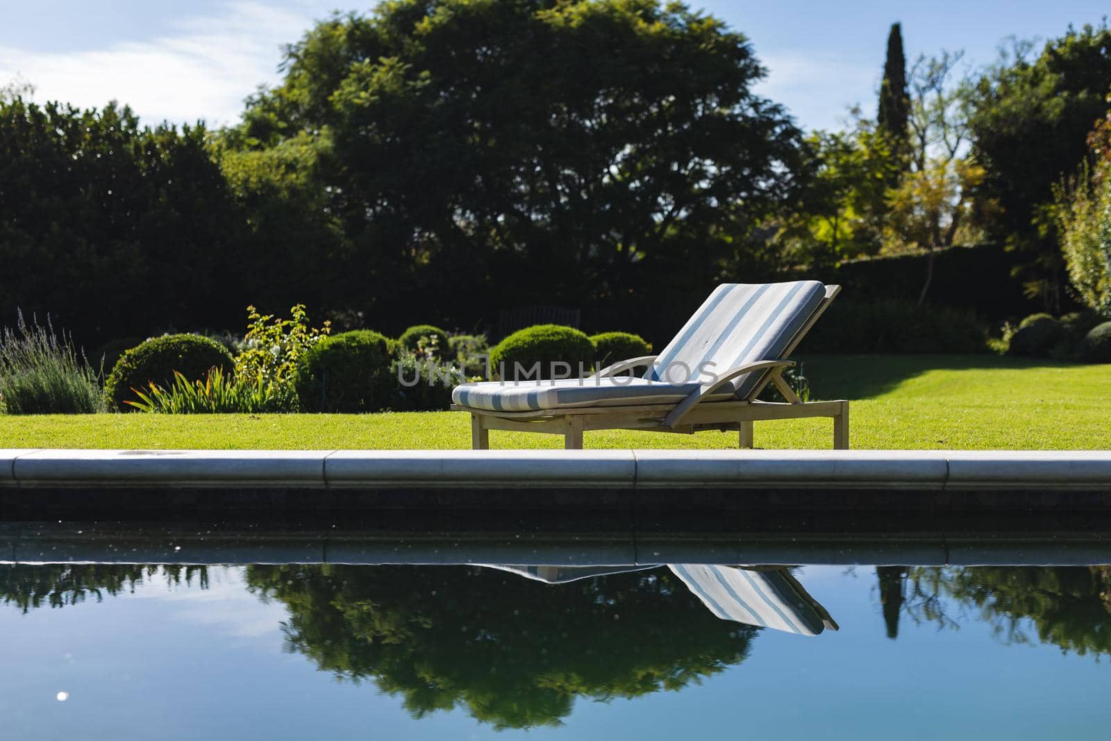 General view of tranquil swimming pool and deckchair with stunning mountains countryside. outdoor retreat and holiday concept.