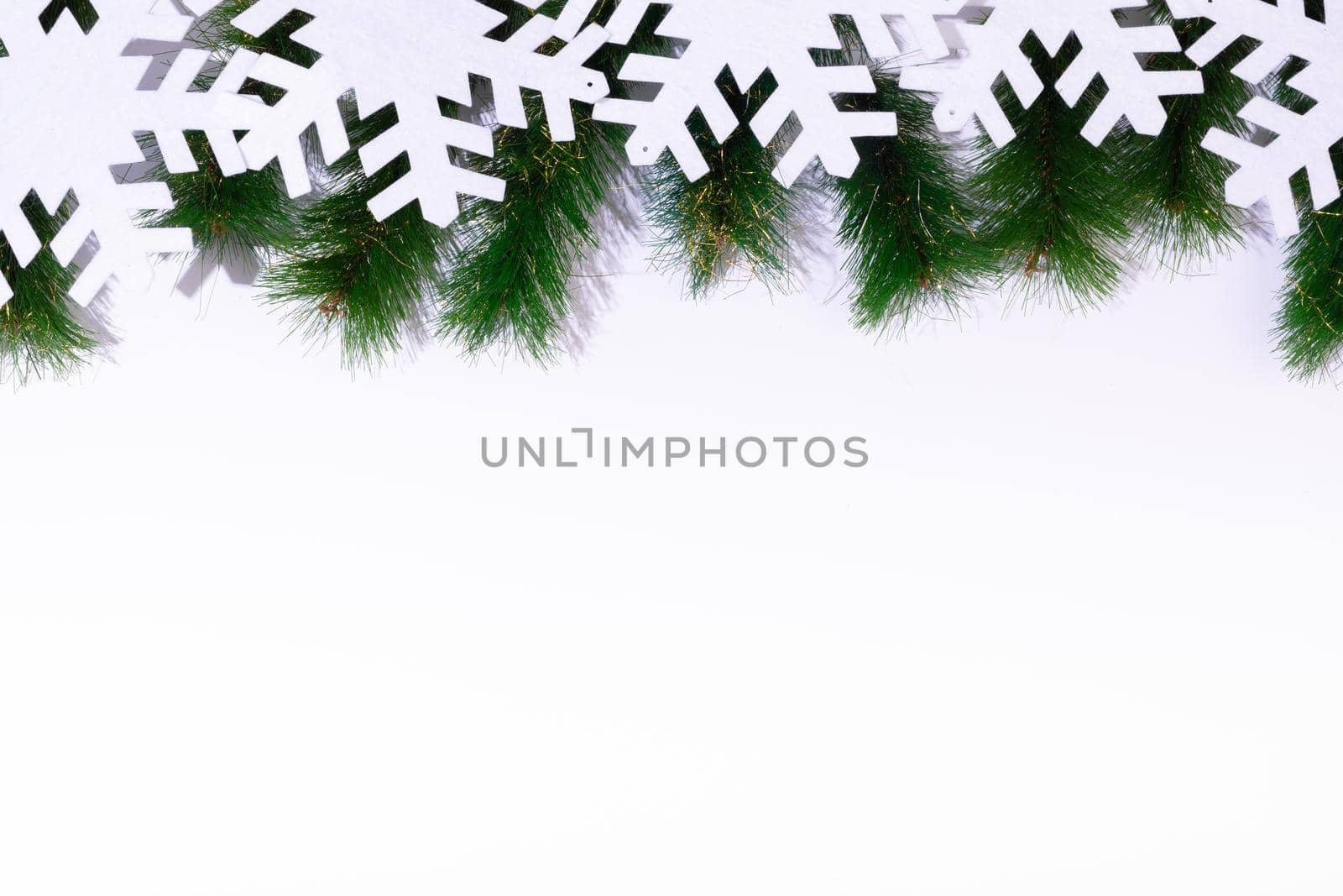 Composition of fir tree branches with snowflakes and copy space on white background. christmas, tradition and celebration concept.