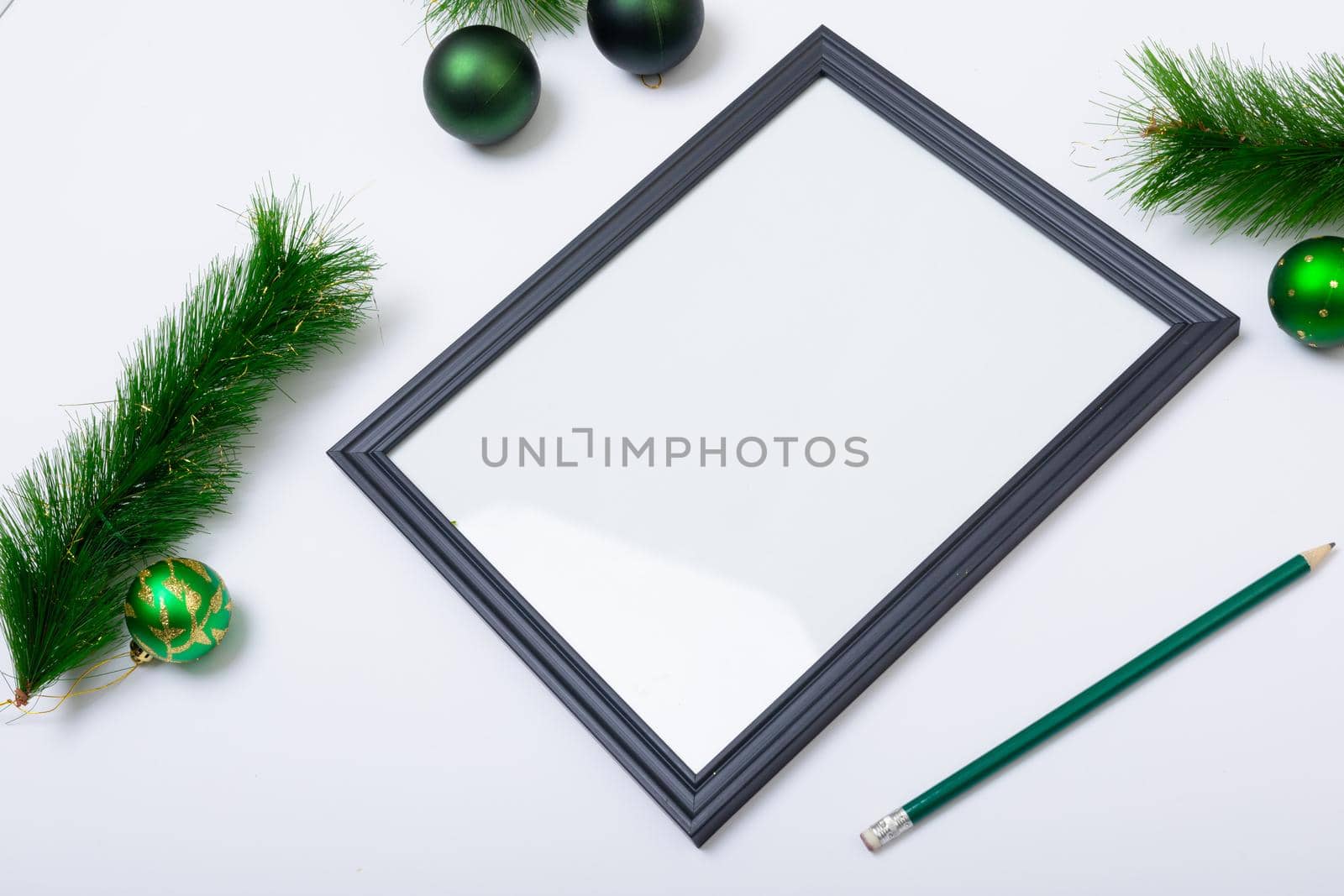 Composition of frame with copy space and fir tree branches with baubles on white background. christmas, tradition and celebration concept.