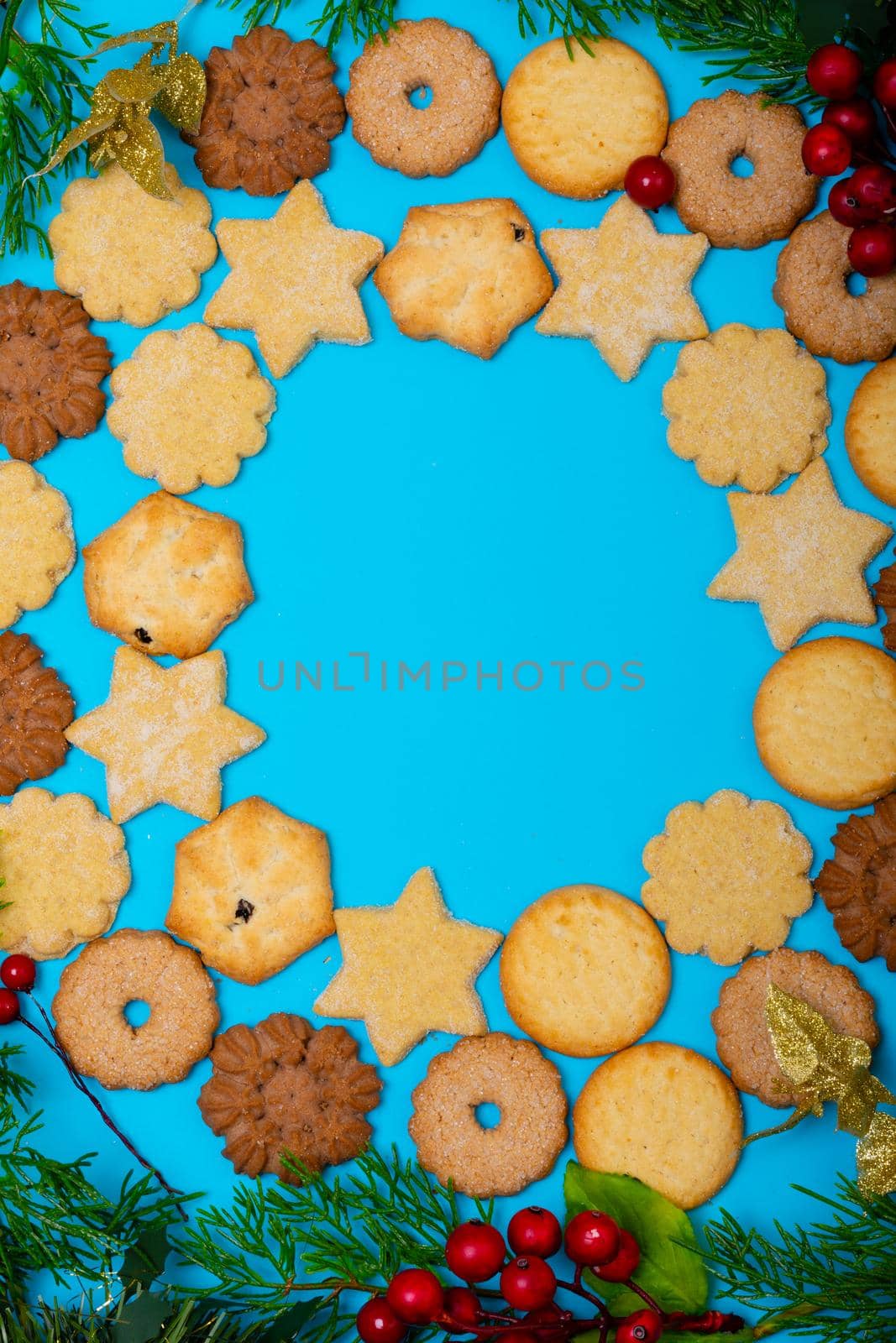 Composition of christmas cookies with tree branches and copy space on blue background by Wavebreakmedia