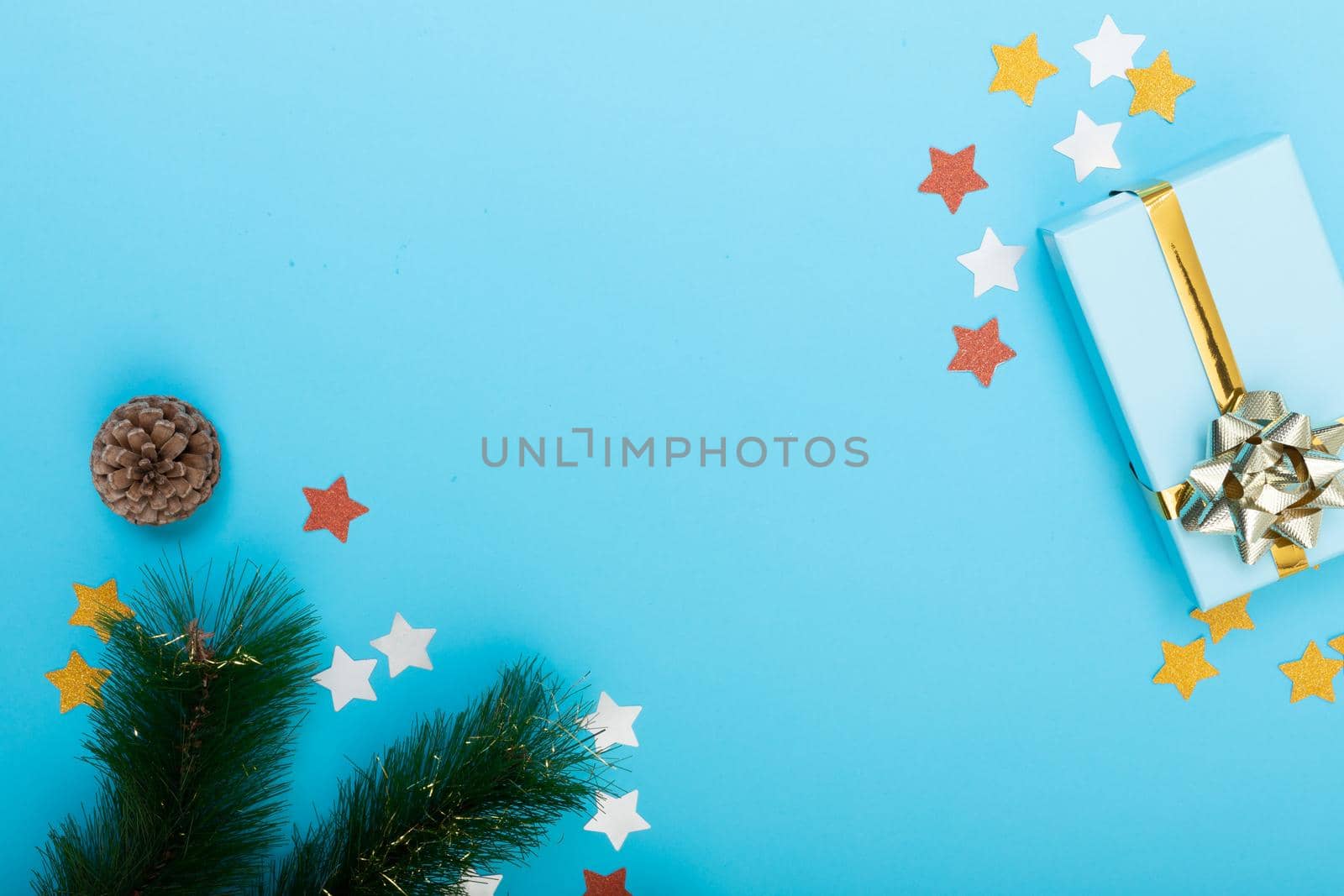 Composition of christmas decorations with tree branches, presents and copy space on blue background by Wavebreakmedia