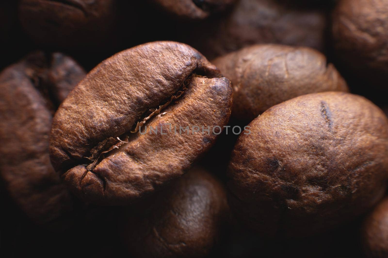 Close up extreme macro group of roasted brown or black coffee beans background in shallow depth of field. Enchanting coffee aroma by yanik88
