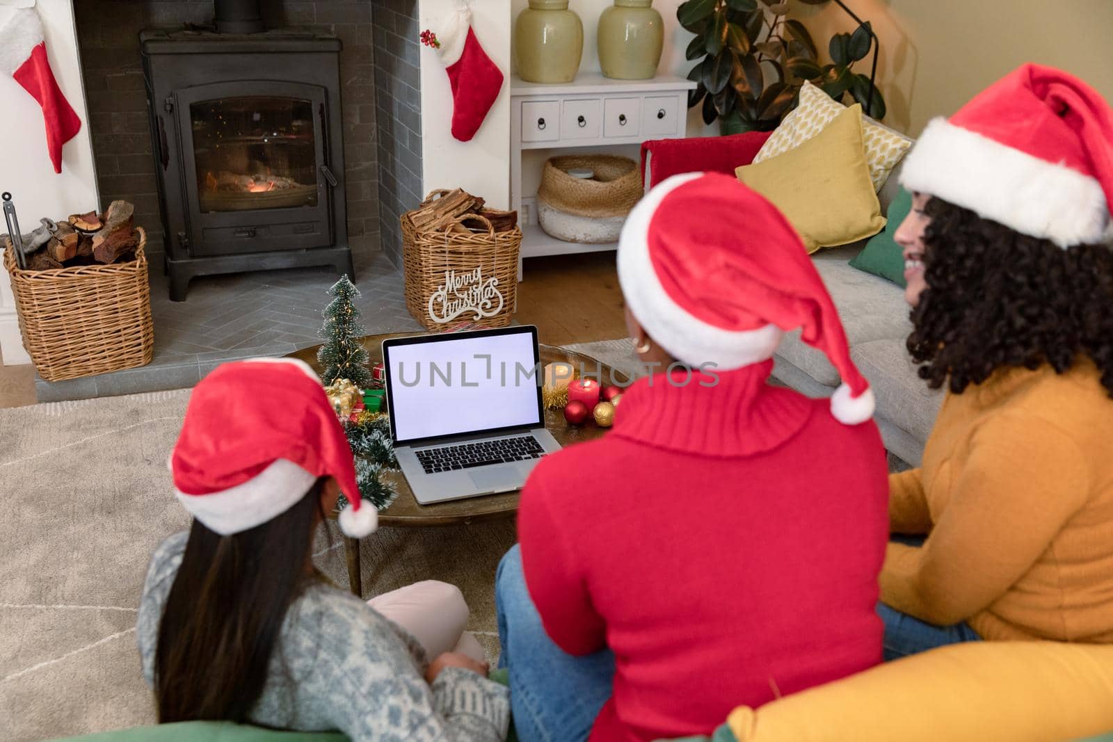 Group of happy diverse female and male friends using laptop with copy space at christmas time by Wavebreakmedia