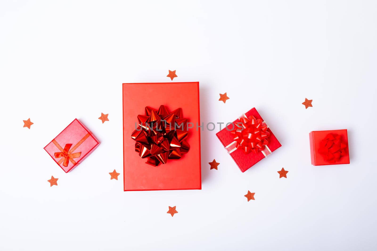 Composition of red christmas presents and stars on white background. christmas, tradition and celebration concept.