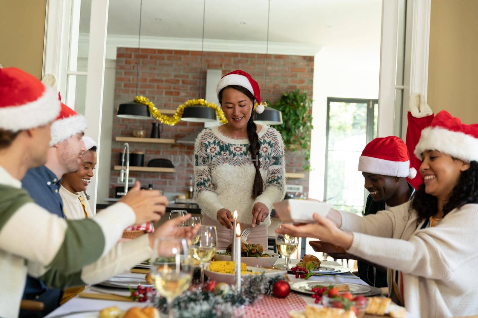 Group of happy diverse female and male friends celebrating christmas at home by Wavebreakmedia