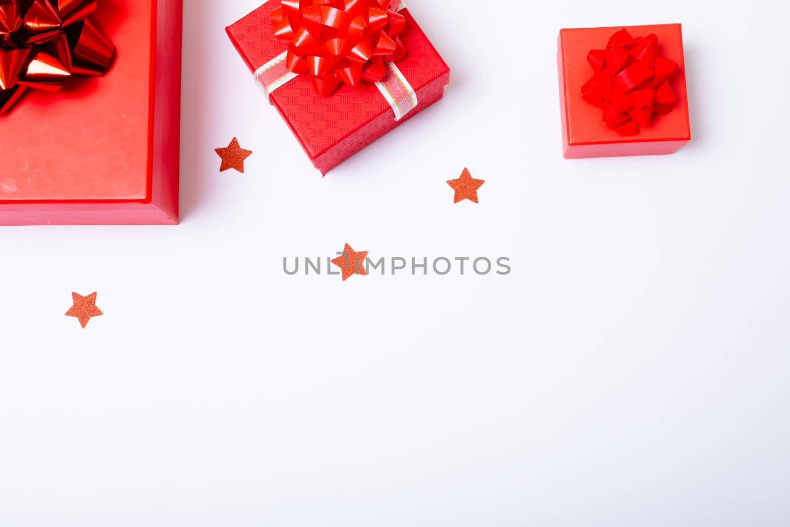 Composition of red christmas presents and stars with copy space on white background. christmas, tradition and celebration concept.