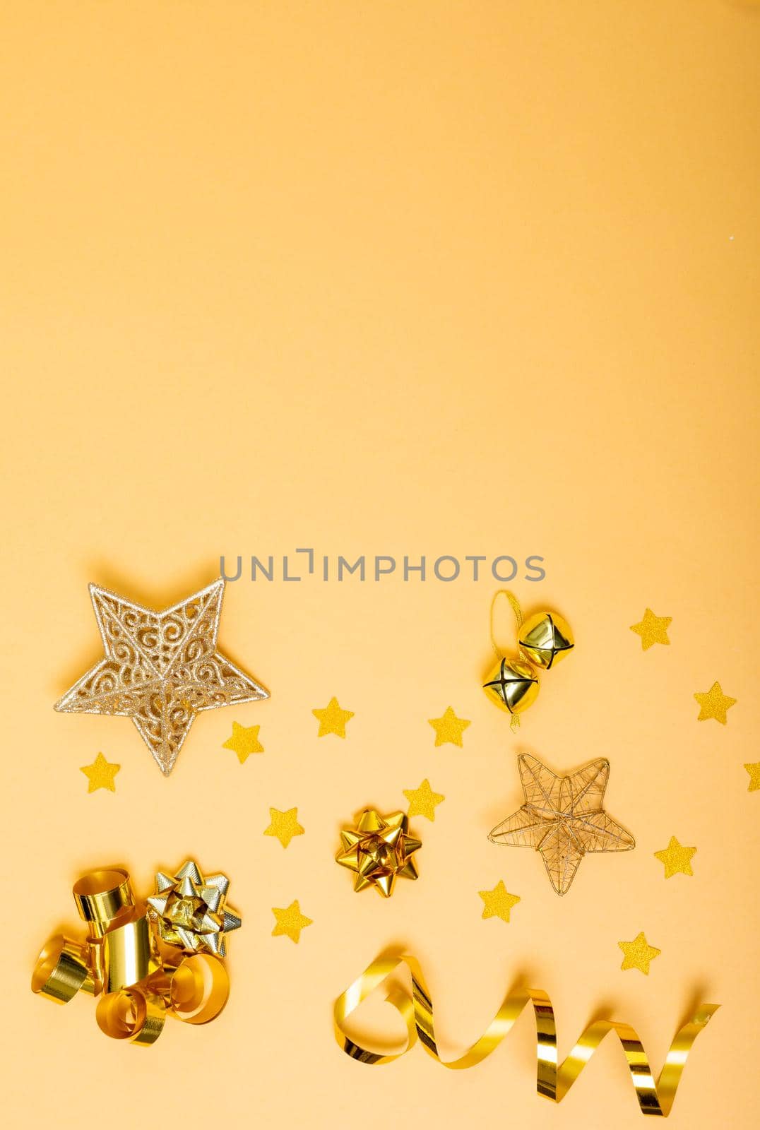 Composition of christmas decorations with ribbons, stars and copy space on yellow background by Wavebreakmedia