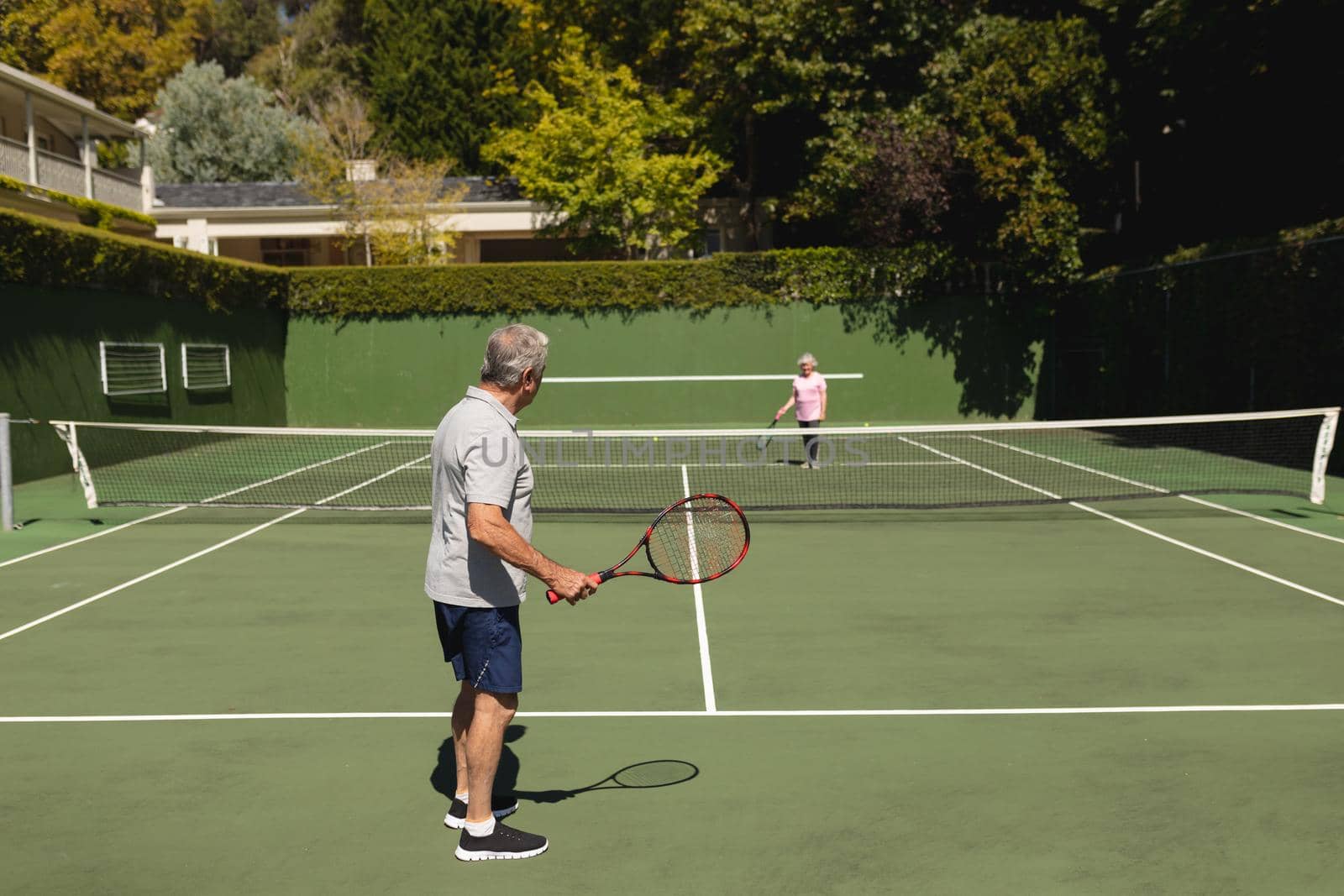 Senior caucasian couple playing tennis together on court by Wavebreakmedia