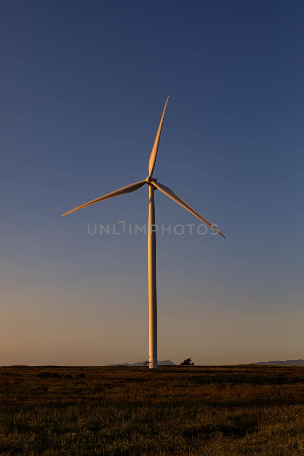 General view of wind turbine in countryside landscape during sunset. environment, sustainability, ecology, renewable energy, global warming and climate change awareness.