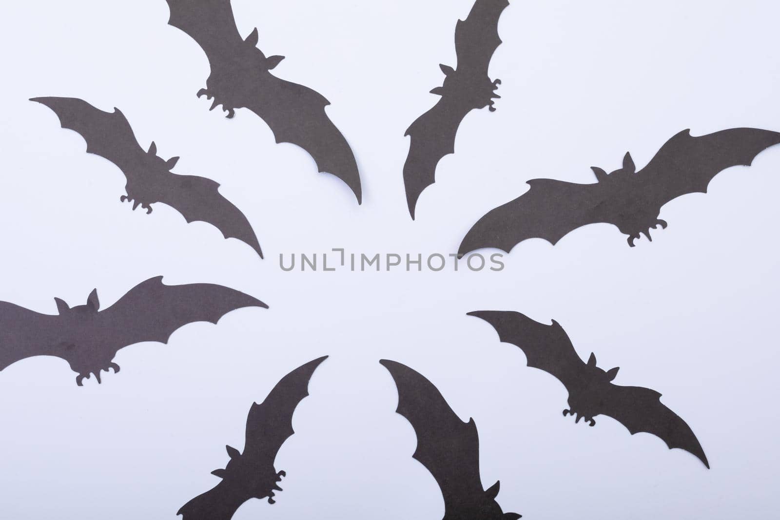 Composition of multiple halloween black bats flying on white background. halloween tradition and celebration concept.