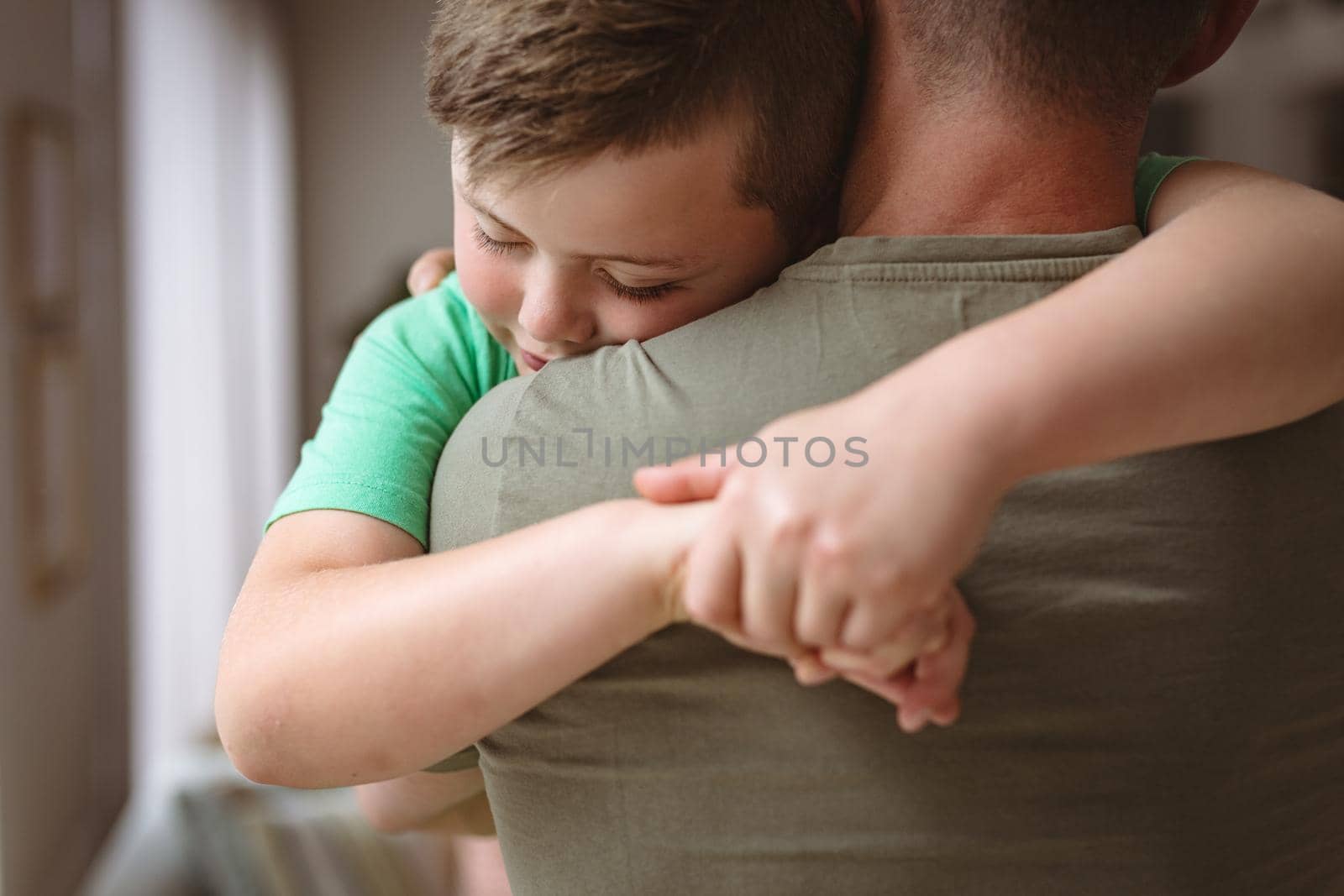 Close up view of caucasian boy hugging his father at home by Wavebreakmedia