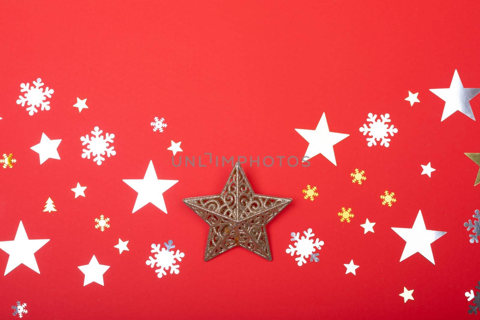 Composition of christmas decorations with stars, snowflakes and copy space on red background. christmas, tradition and celebration concept.