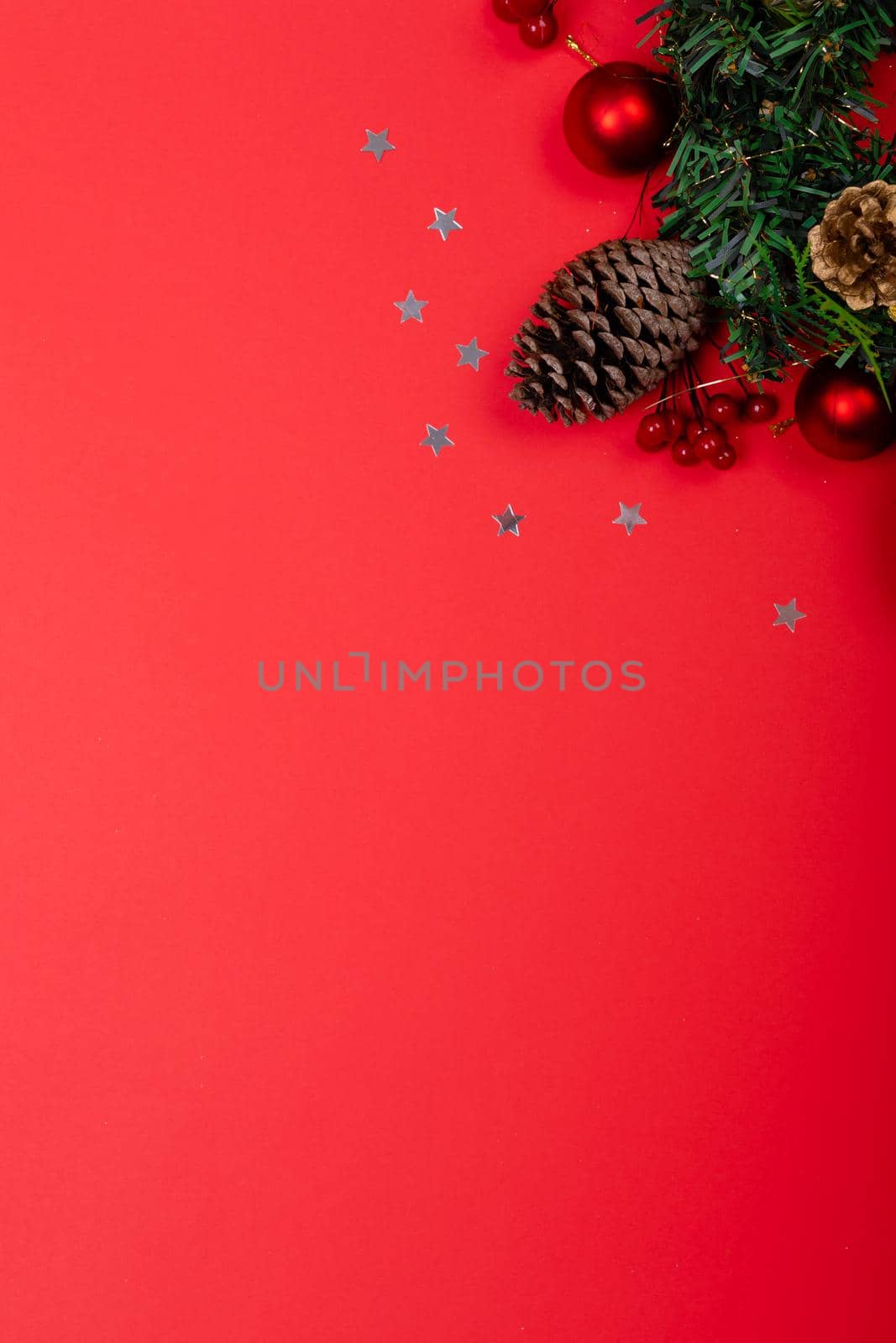 Composition of christmas decorations with pine cones, stars and copy space on red background by Wavebreakmedia
