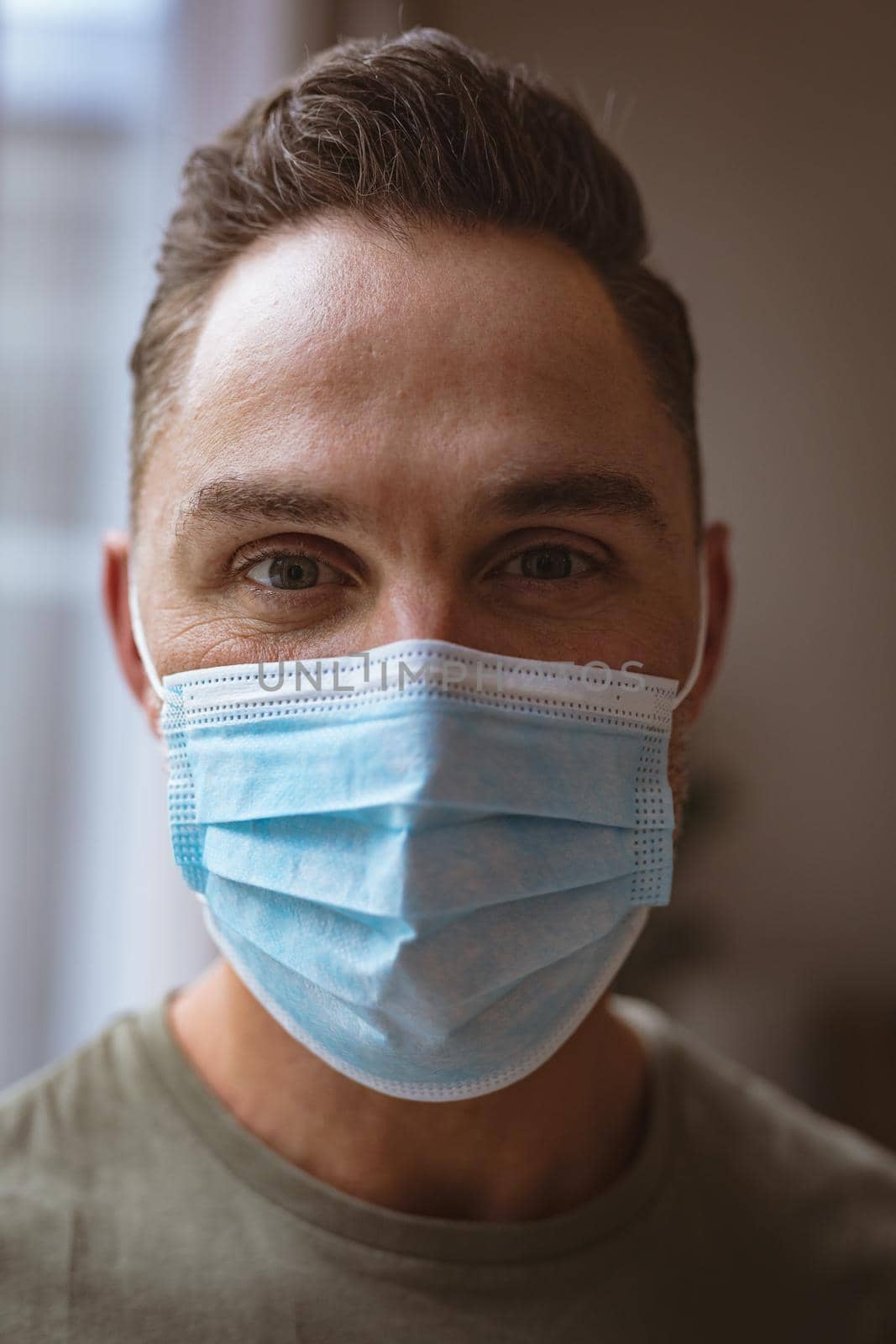 Close up view of caucasian man wearing face mask at home. coronavirus covid-19 pandemic concept