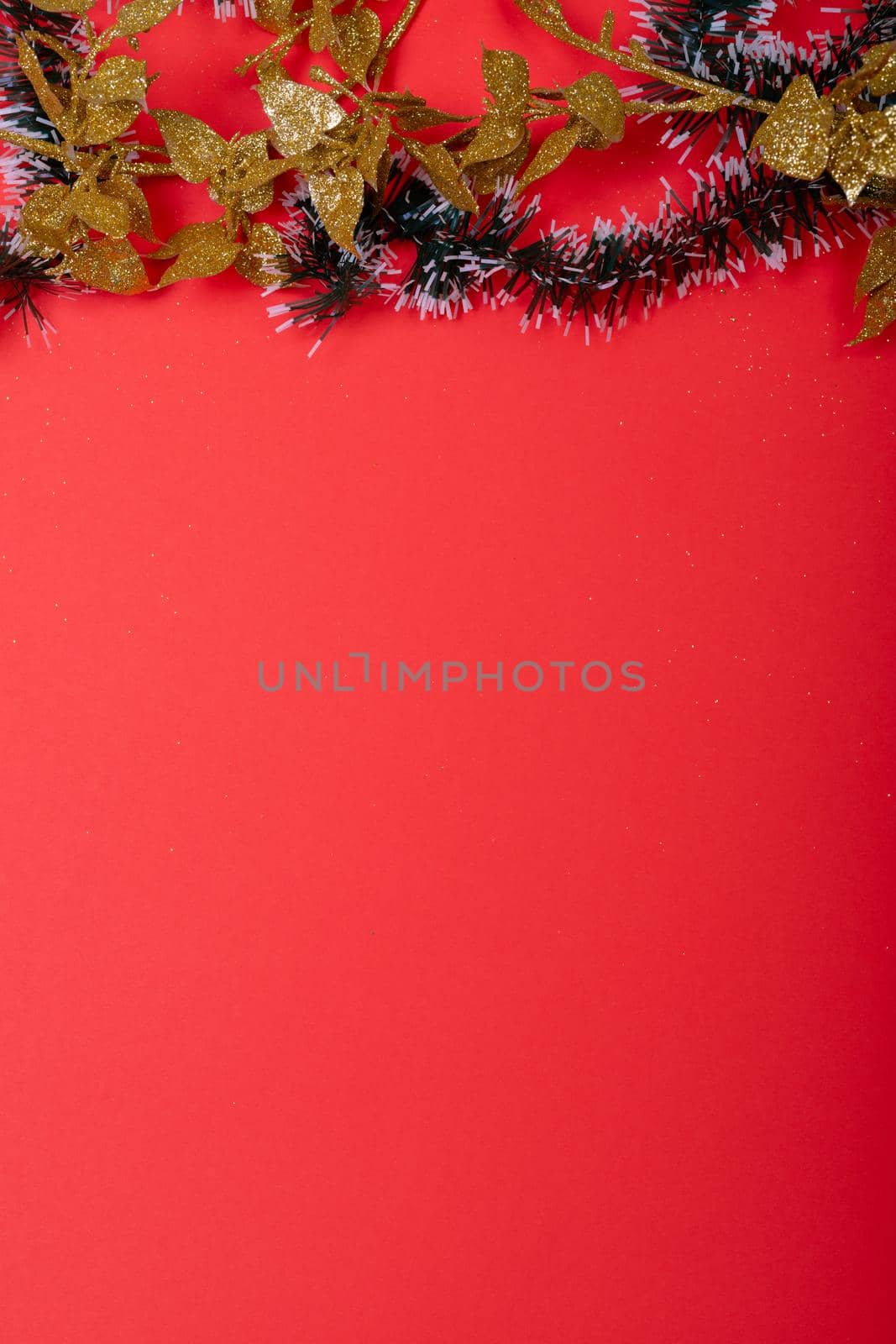 Composition of christmas decorations with garland and copy space on red background by Wavebreakmedia