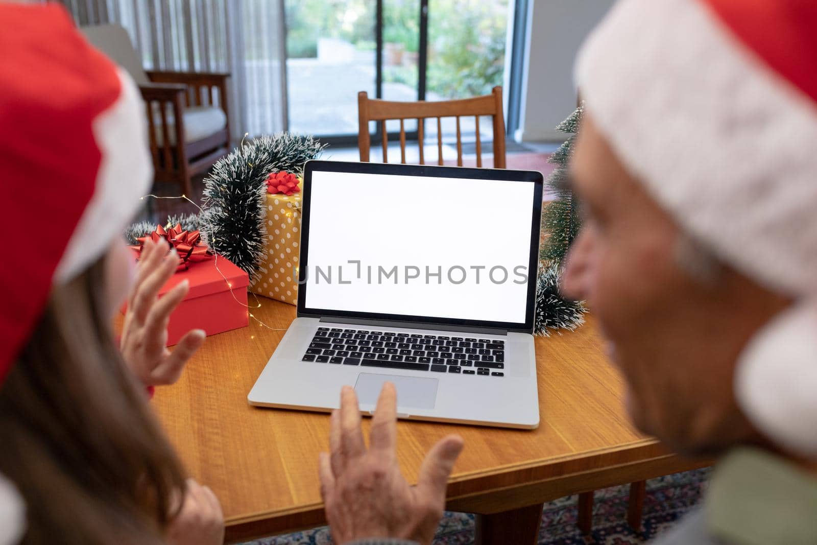 Caucasian woman and senior man having video call on laptop with copy space at christmas time by Wavebreakmedia