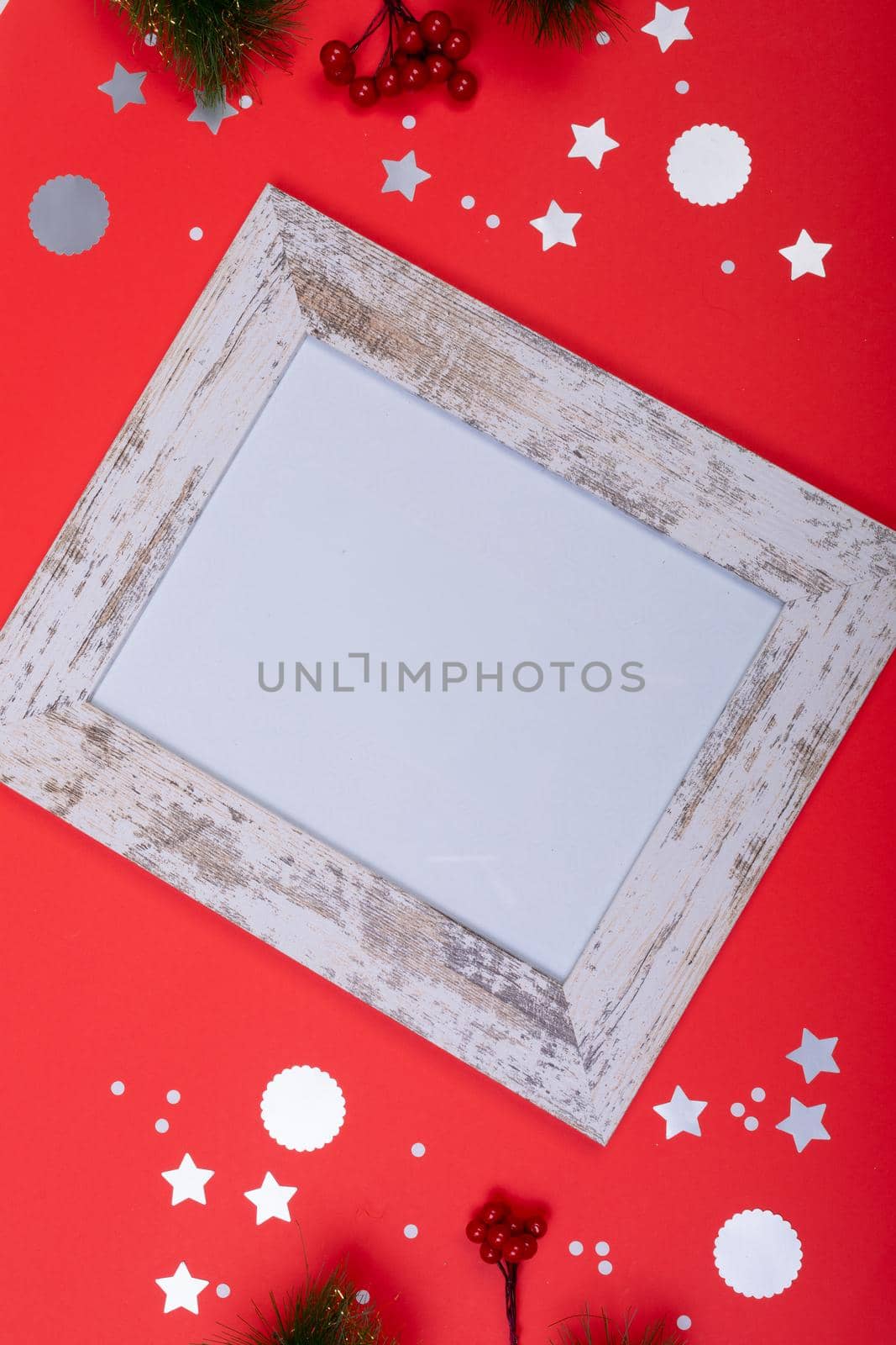 Composition of white card in frame with copy space and christmas decorations on red background by Wavebreakmedia