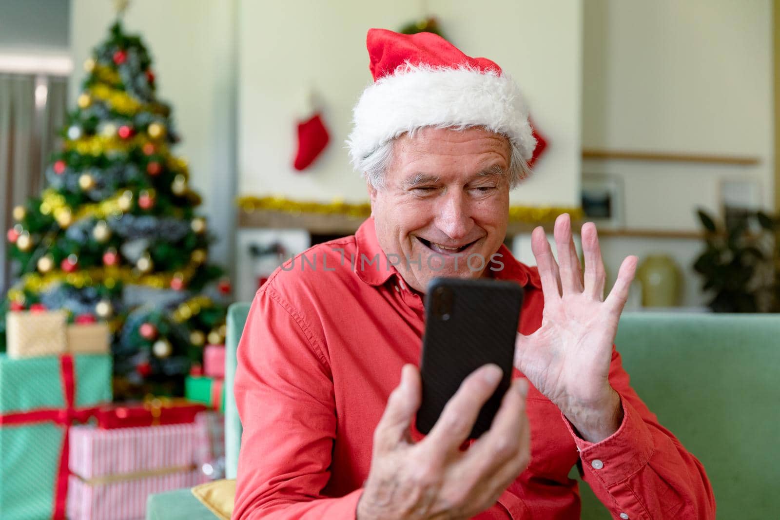 Happy caucasian senior man wearing santa hat having video call on smartphone at christmas time by Wavebreakmedia