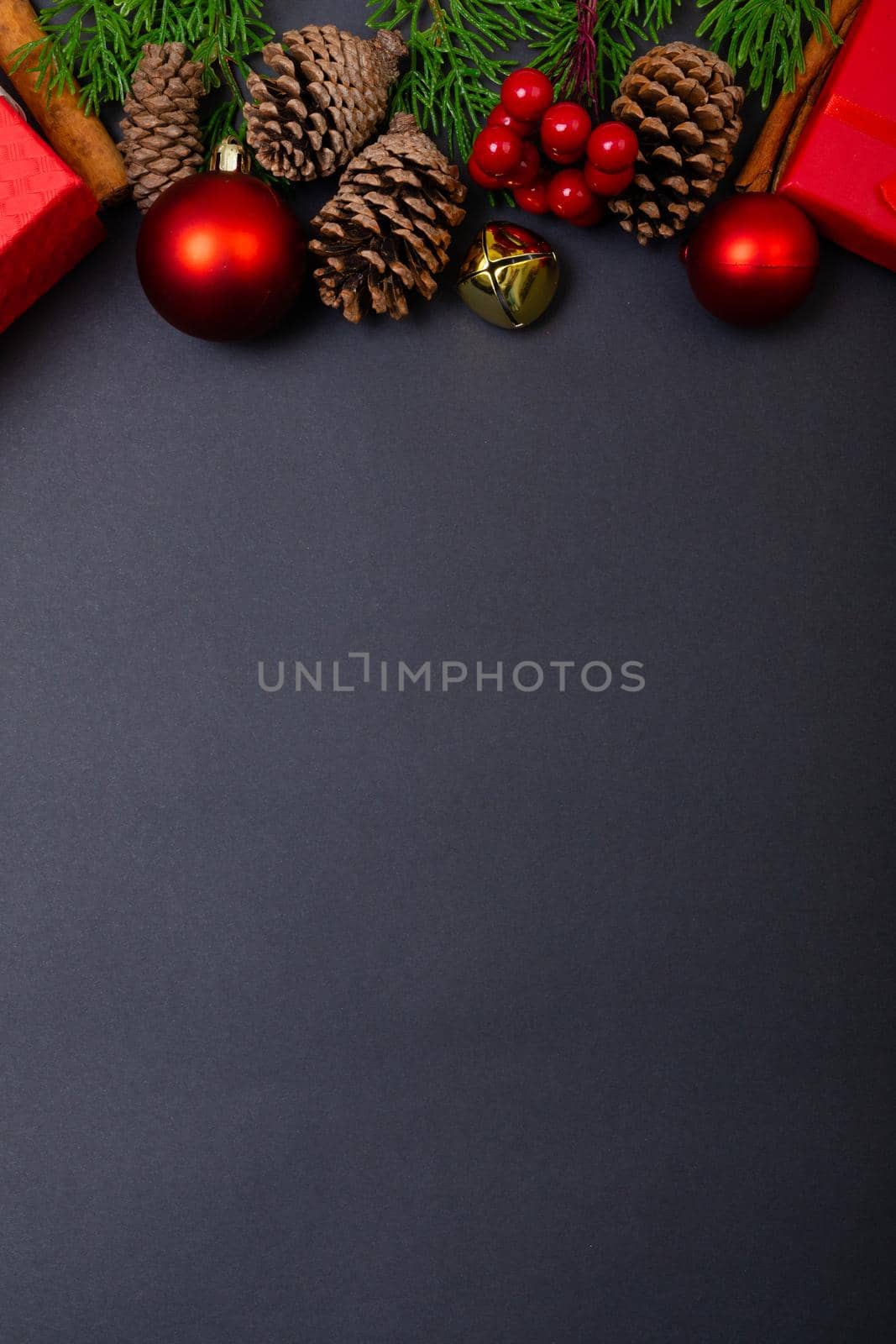 Composition of christmas decorations with baubles, presents and copy space on black background by Wavebreakmedia
