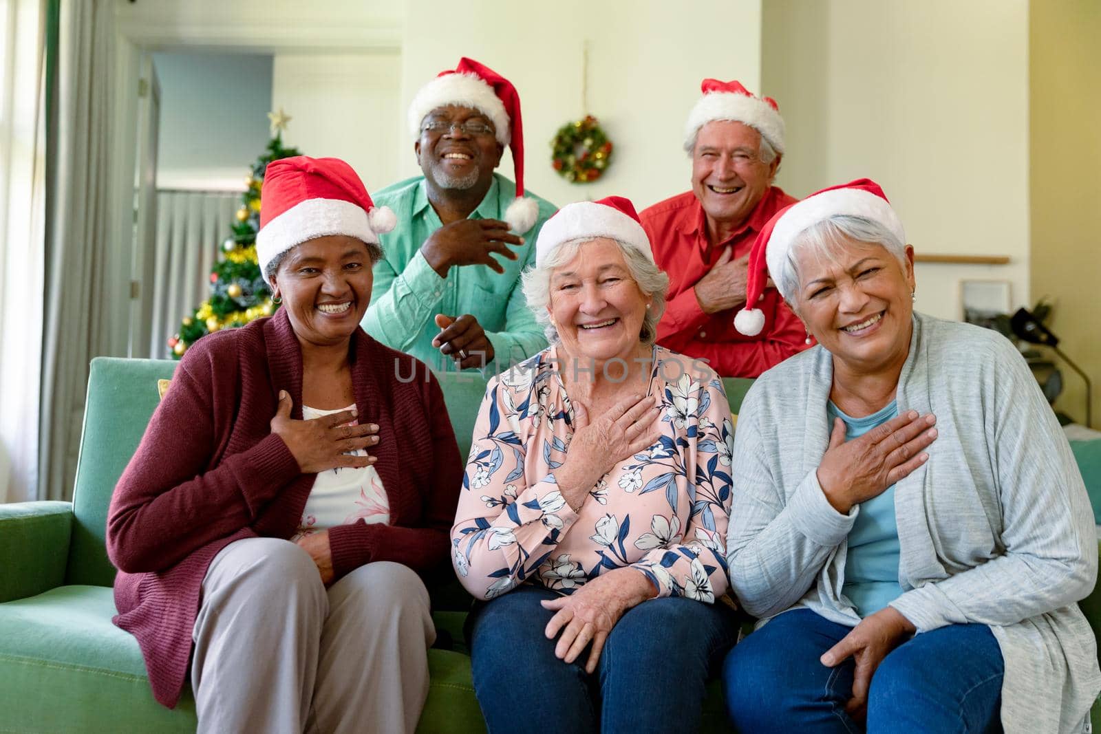 Group of happy diverse group of senior friends in santa hats having video call at christmas time by Wavebreakmedia