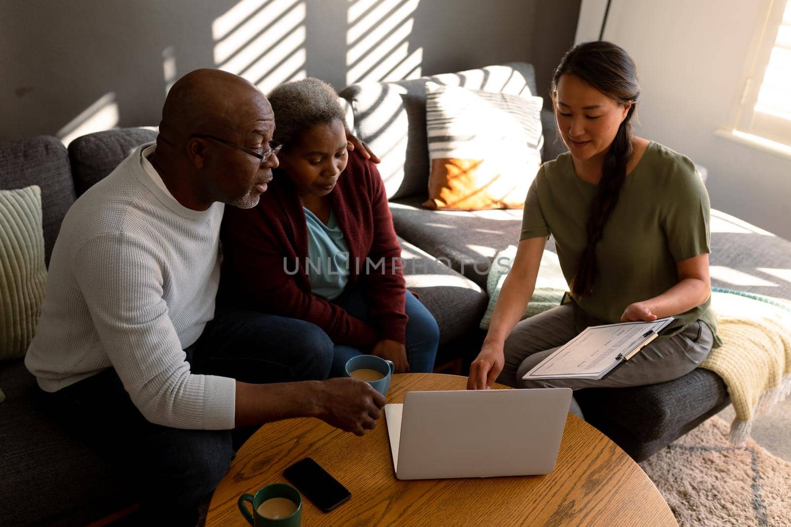 African american senior couple having meeting with asian female financial advisor at home by Wavebreakmedia