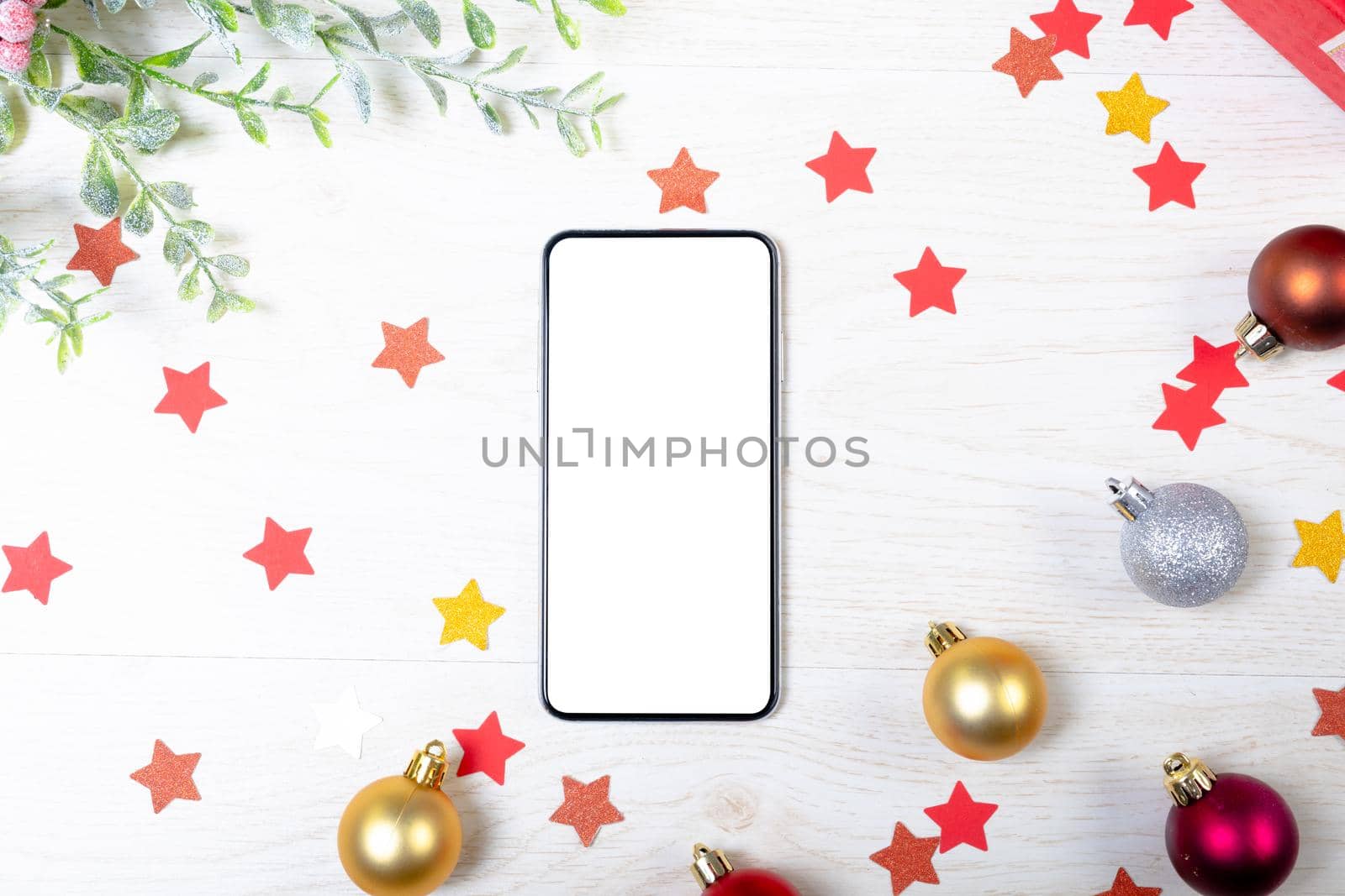 Composition of smartphone with copy space and christmas decorations on white background. christmas, communication, tradition and celebration concept.