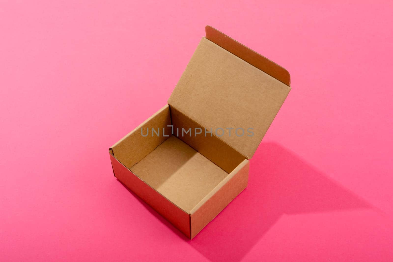 Composition of open empty cardboard gift box on pink background. christmas, gift, tradition and celebration concept.