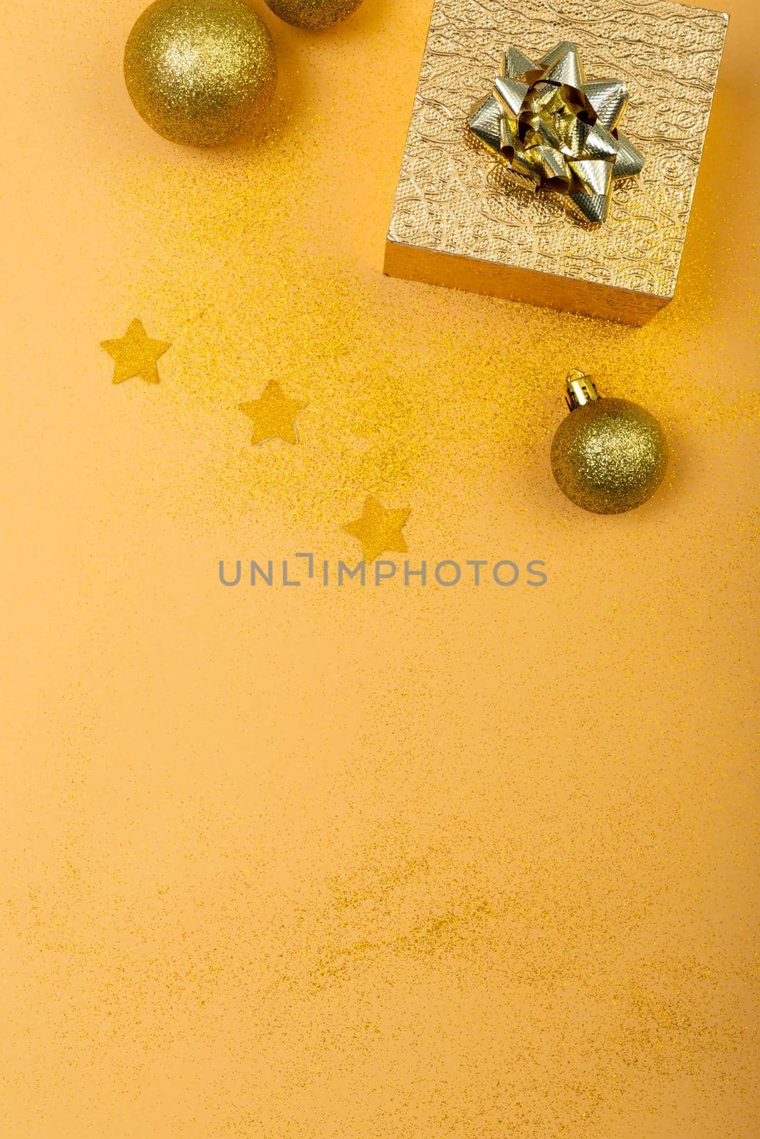 Composition of christmas decorations with present, baubles and copy space on yellow background by Wavebreakmedia