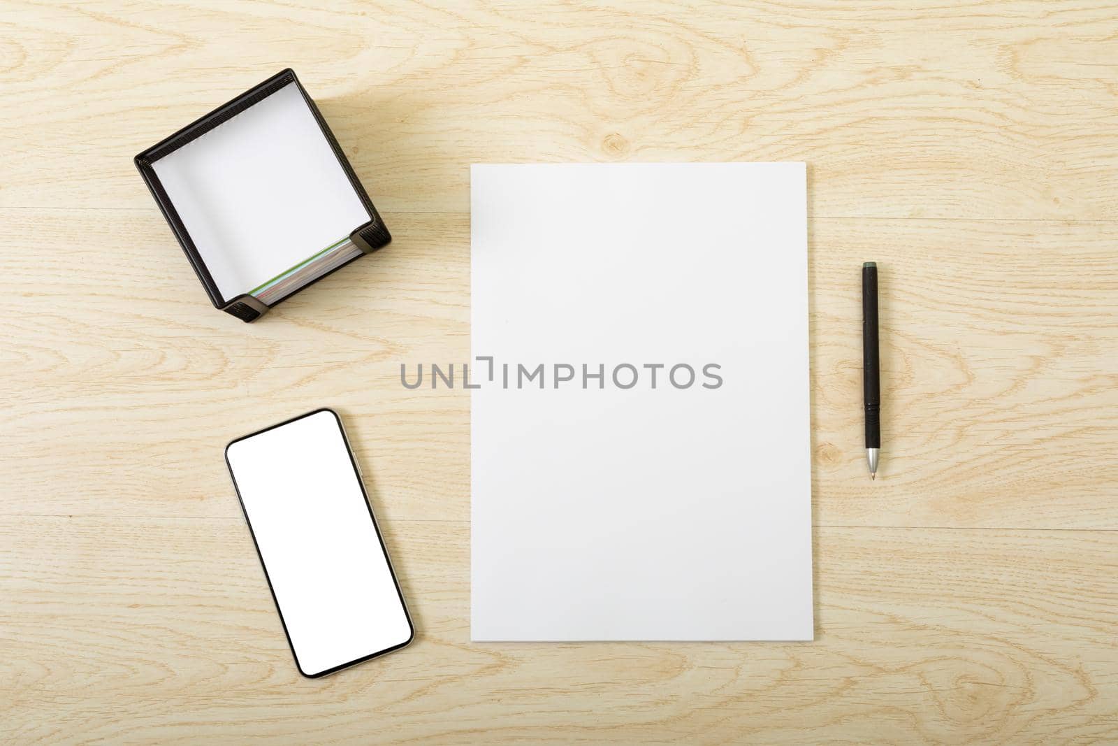 Composition of white card and smartphone with copy space on wooden background. communication, modern office and technology concept.